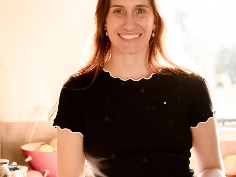 A support worker relaxed by a sunlit window in a warm home interior