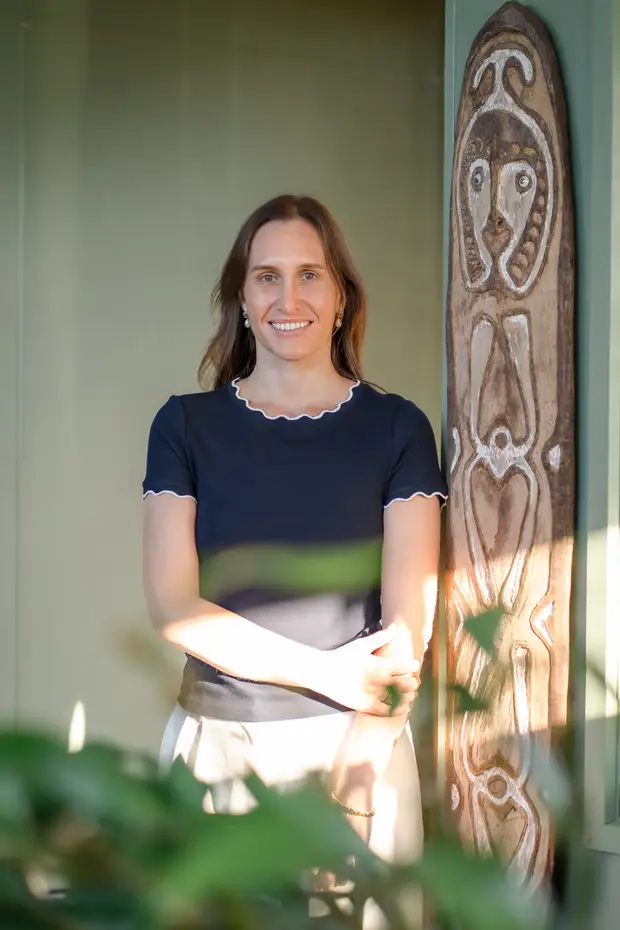 A Grove Support Services team member smiling in a sunlit doorway