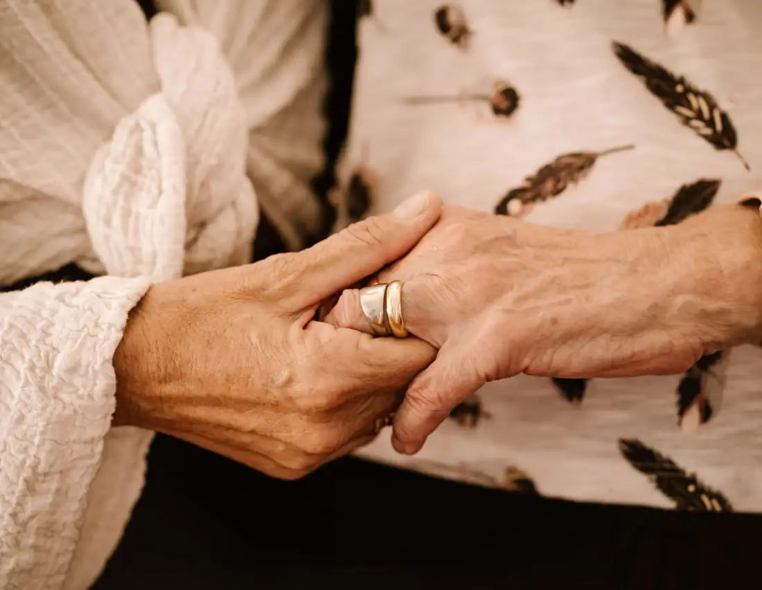 Two people holding hands in a warm indoor setting