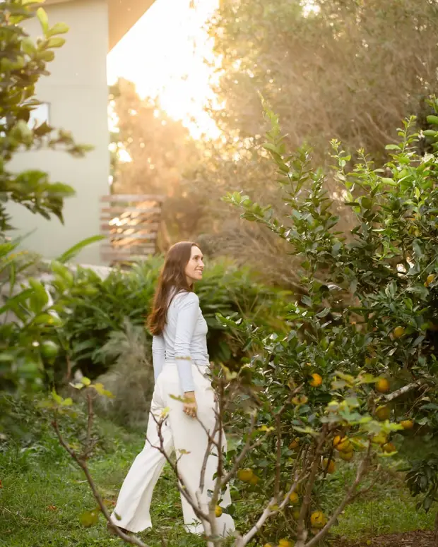 A woman enjoying a walk through a sunlit garden