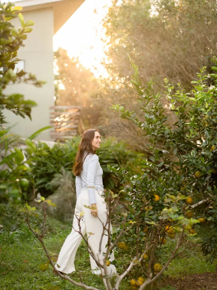 A woman enjoying a walk through a sunlit garden