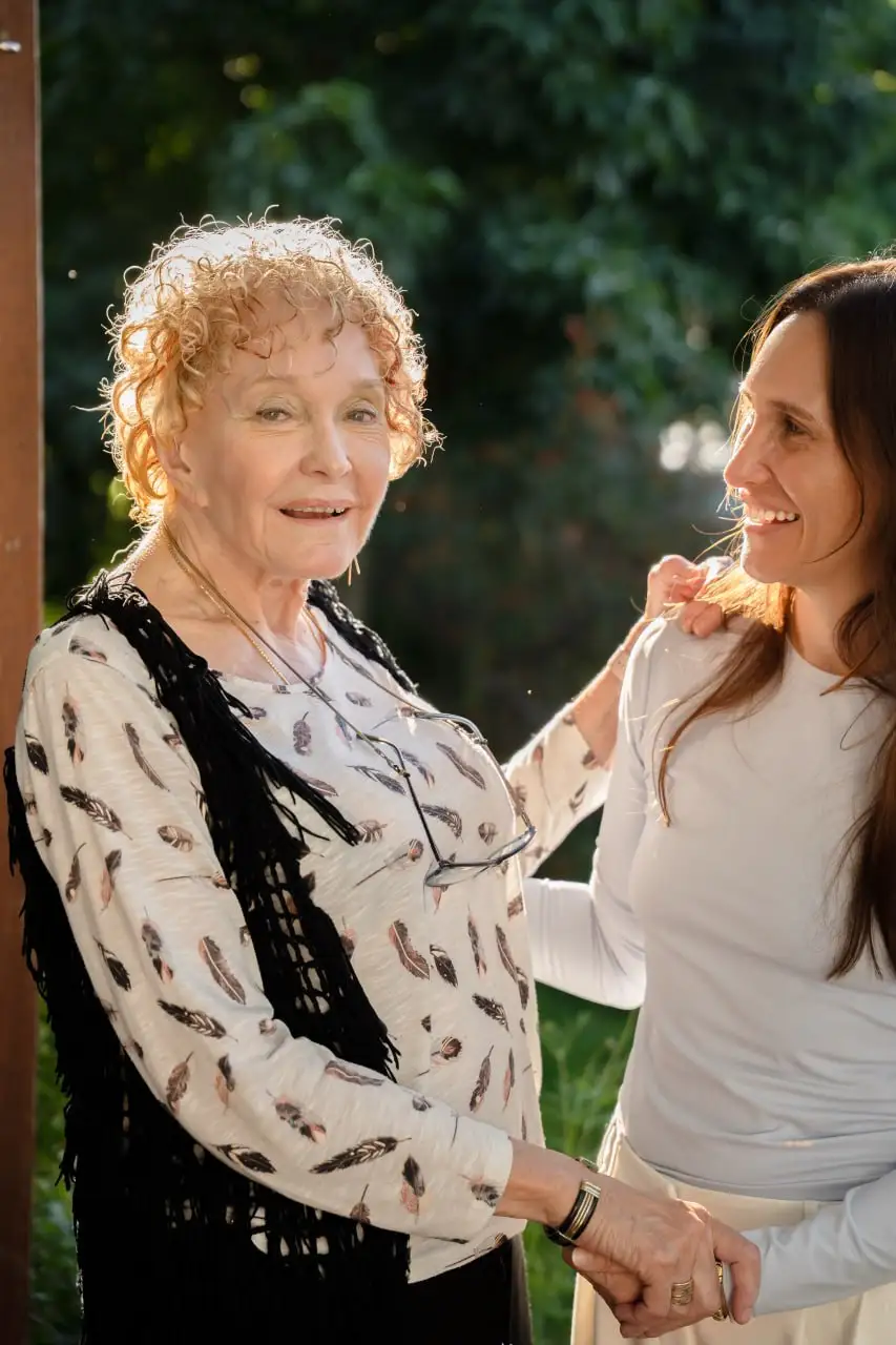 A support worker and an older woman in golden sunlight